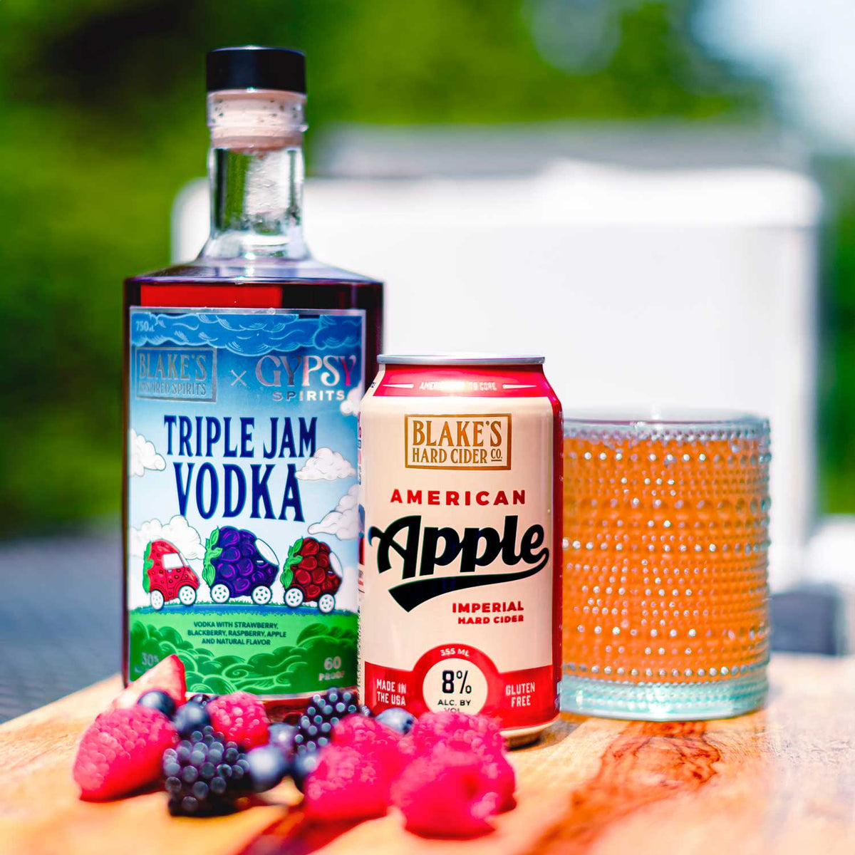 A bottle of Blake's x Gypsy Spirits Triple Jam Vodka and a can of American Apple cider with fresh berries