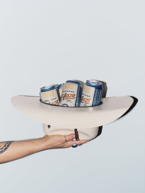 A cowboy hat full of Blake's American Haze cans held out at arm's length