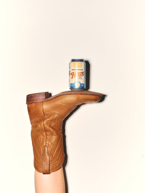 Blake's American Haze can balanced on the toe of a cowboy boot