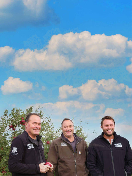 Three members of the Blake's Hard Cider team standing in the orchard