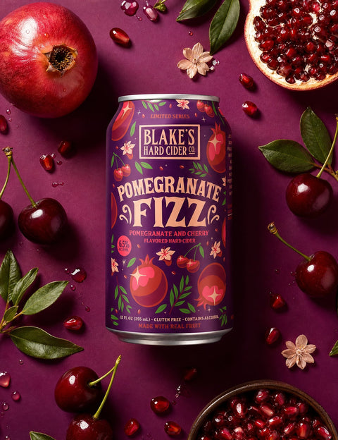 Blake's Hard Cider Pomegranate Fizz can among pomegranates and cherries